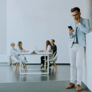 En forretningsmand bruger en løsning på sin telefon, som er lavet med Power Apps