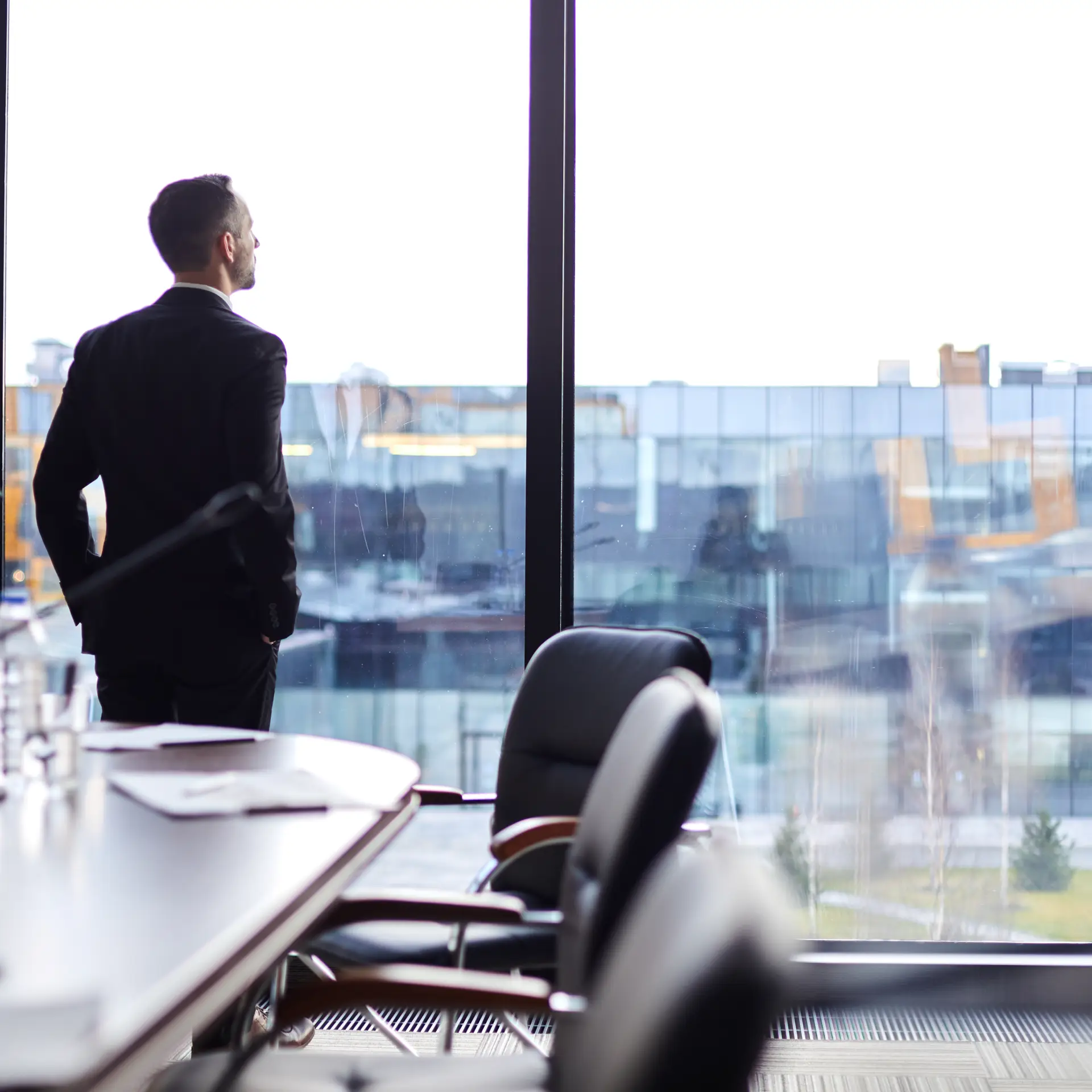 En leder står på sit kontor og kigger ud af vinduet og tænker over sit nye kvalitetssystem til håndtering af ISO 9001