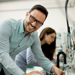 Mand i produktion smiler da han bruger SharePoint agents