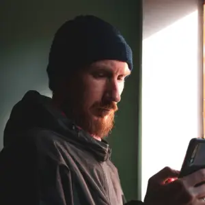 Arbejder med hue tjekker sin projektportal på sin telefon, som er udarbejdet af Blue Dock