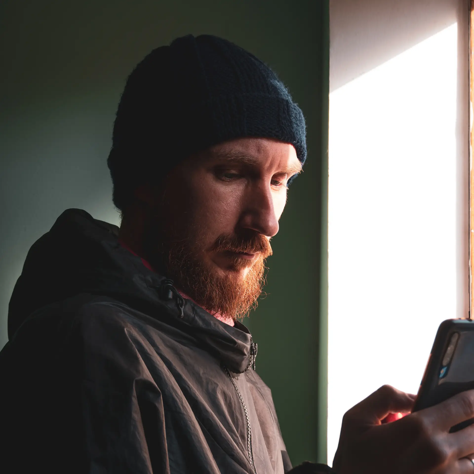 Arbejder med hue tjekker sin projektportal på sin telefon, som er udarbejdet af Blue Dock