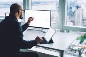 Mand sider og arbejder i sin SharePoint projektportal fra bluedock