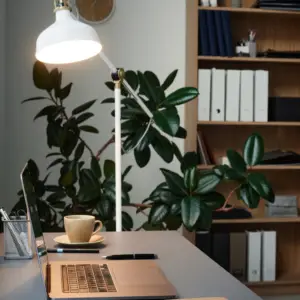 Et minimalistisk kontorbillede med en åben laptop på bordet, men intet menneske, hvilket skal illustrerer en Microsoft Copilot Agent, som arbejder mens ingen andre gør