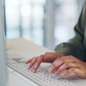Medarbejder skriver på et tastatur og søger sin i medarbejderhåndbog i SharePoint fra Blue Dock