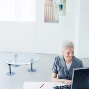 Kvinde sidder ved computer med SharePoint kvalitetsstyring, som er en løsning fra Blue Dock