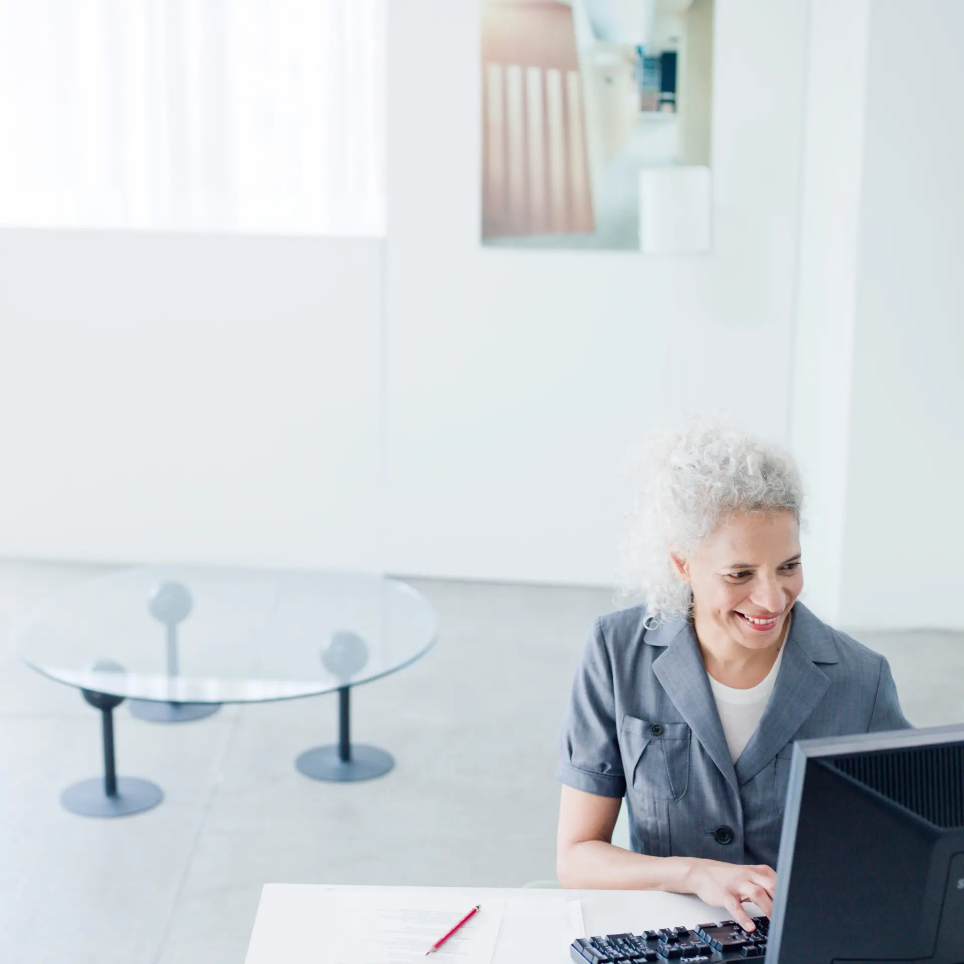 Kvinde sidder ved computer med SharePoint kvalitetsstyring, som er en løsning fra Blue Dock